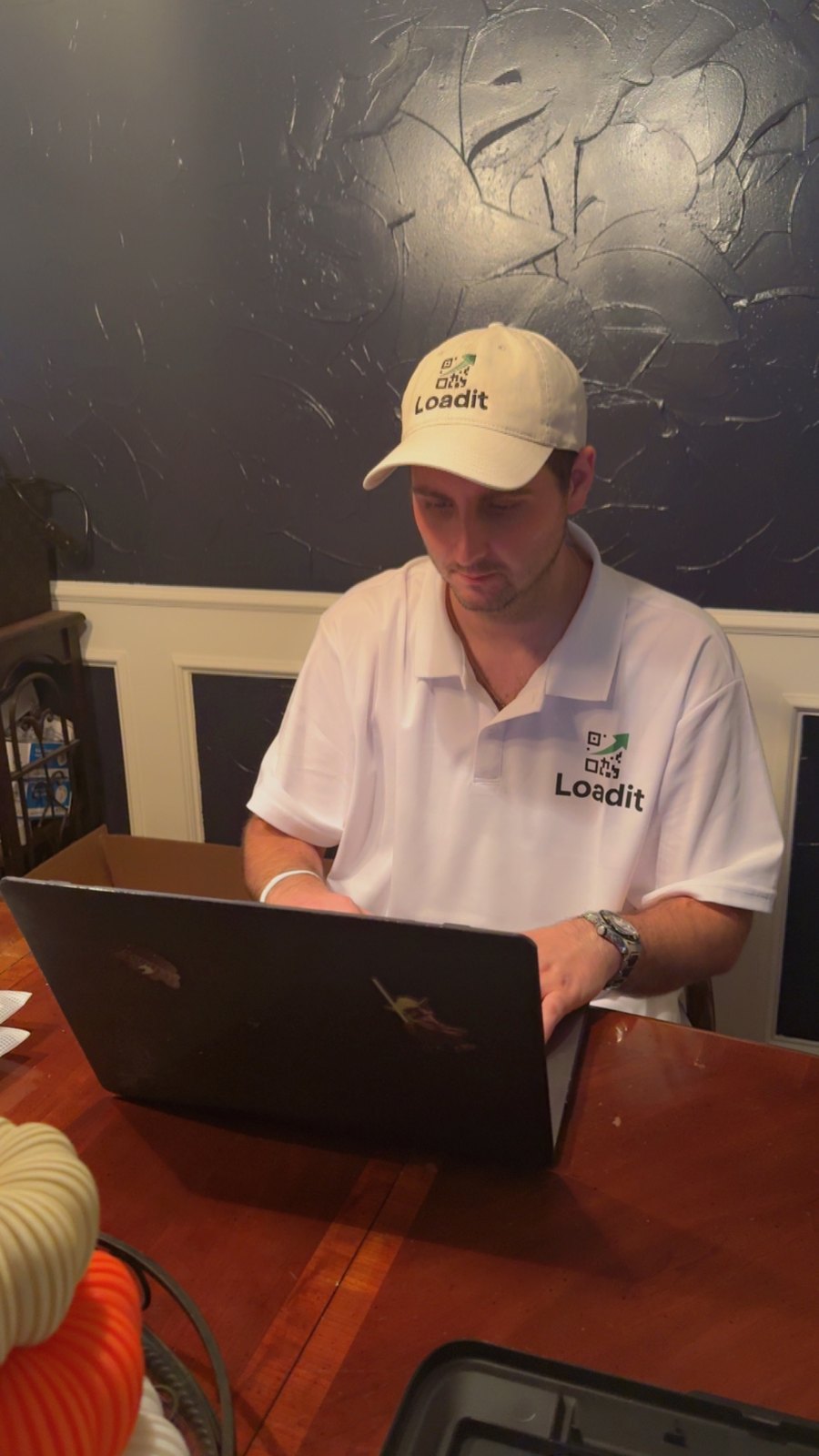 Colt in Loadit gear, heads-down on a laptop, building Loadit